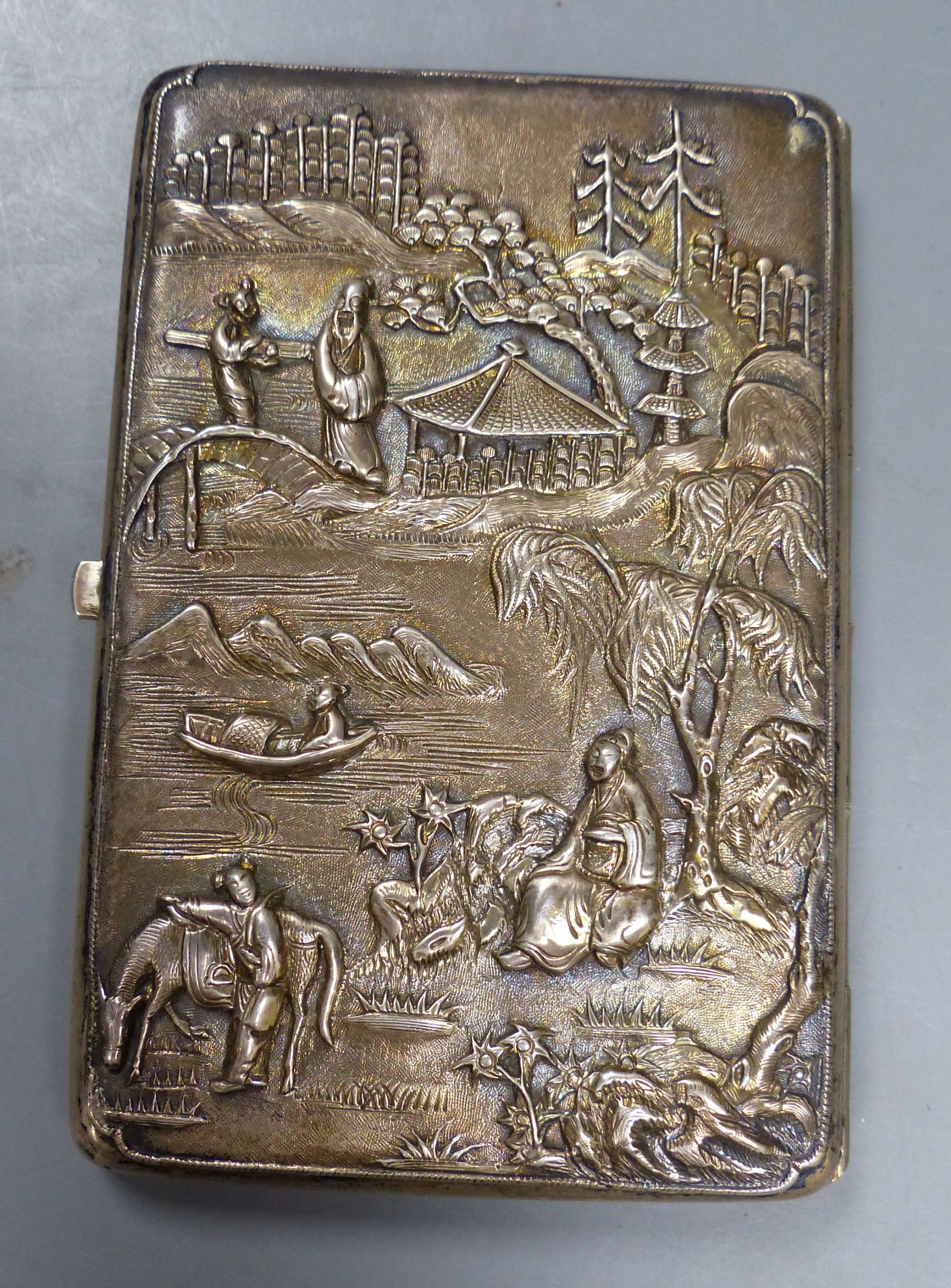 A late 19th century Chinese Export white metal card case, decorate with figures at various pursuits in landscape scene,